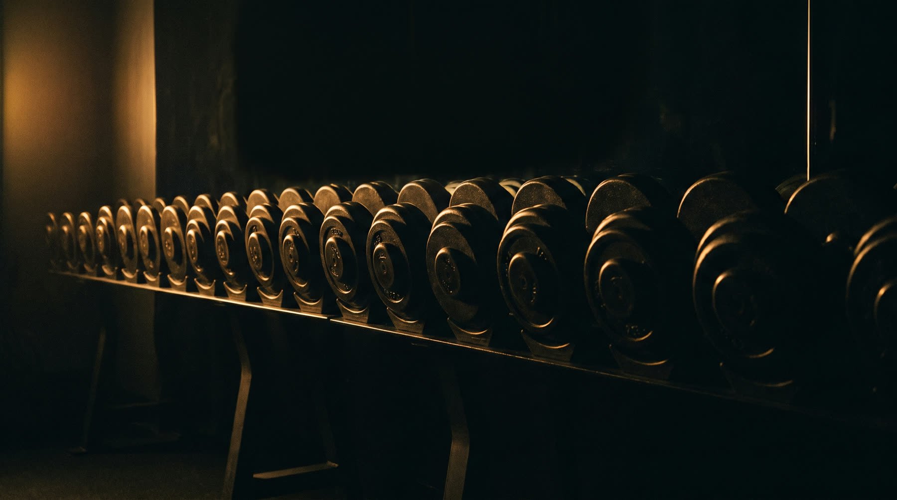 A rack of cast iron dumbbells ordered light to heavy